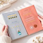 Open embroidery stitch practice book held by hand, showing floral embroidery patterns and different stitch techniques