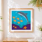 Finished dolphin and clownfish under the sea cross stitch artwork displayed