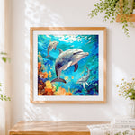 Finished dolphin family in coral reef cross stitch artwork displayed