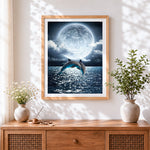 Finished dolphins jumping under a full moon cross stitch artwork displayed