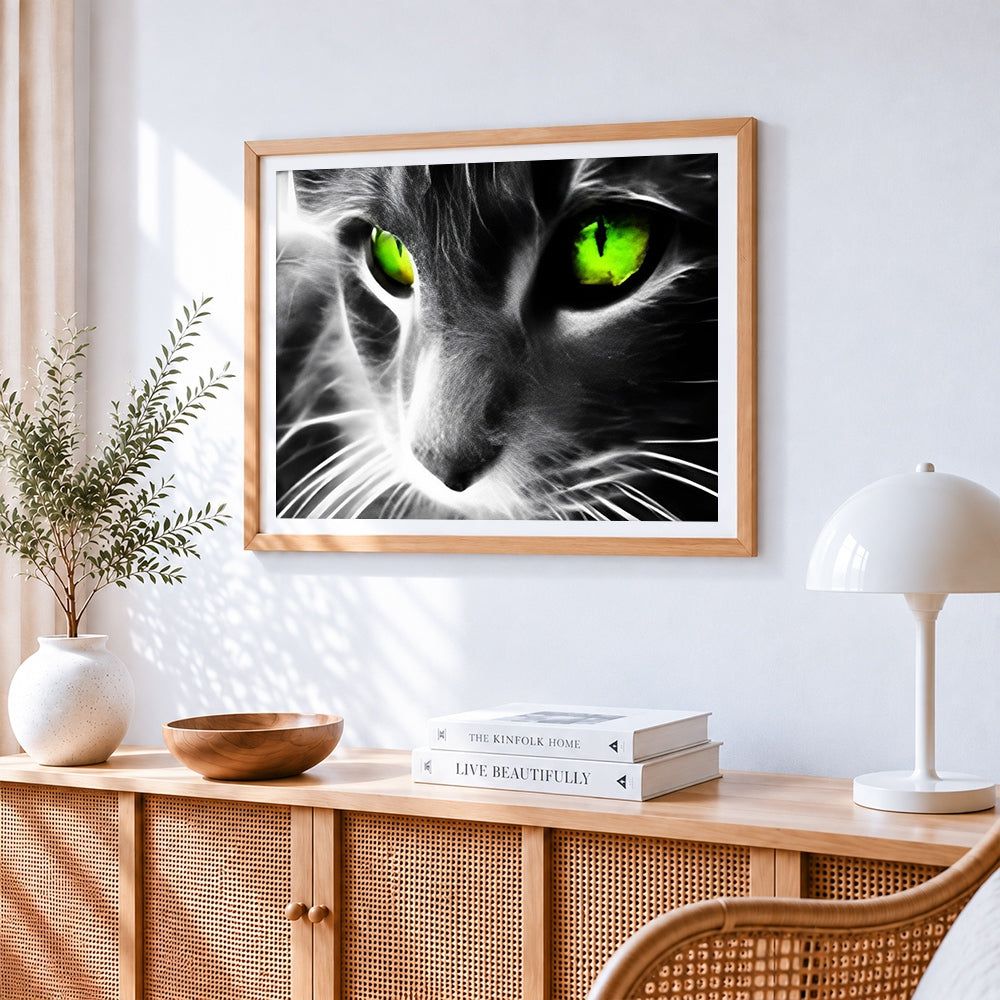 Dramatic cat with neon green eyes cross stitch artwork displayed on wall as home decor