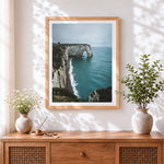 Finished dramatic coastal cliffs and sea arch cross stitch artwork displayed