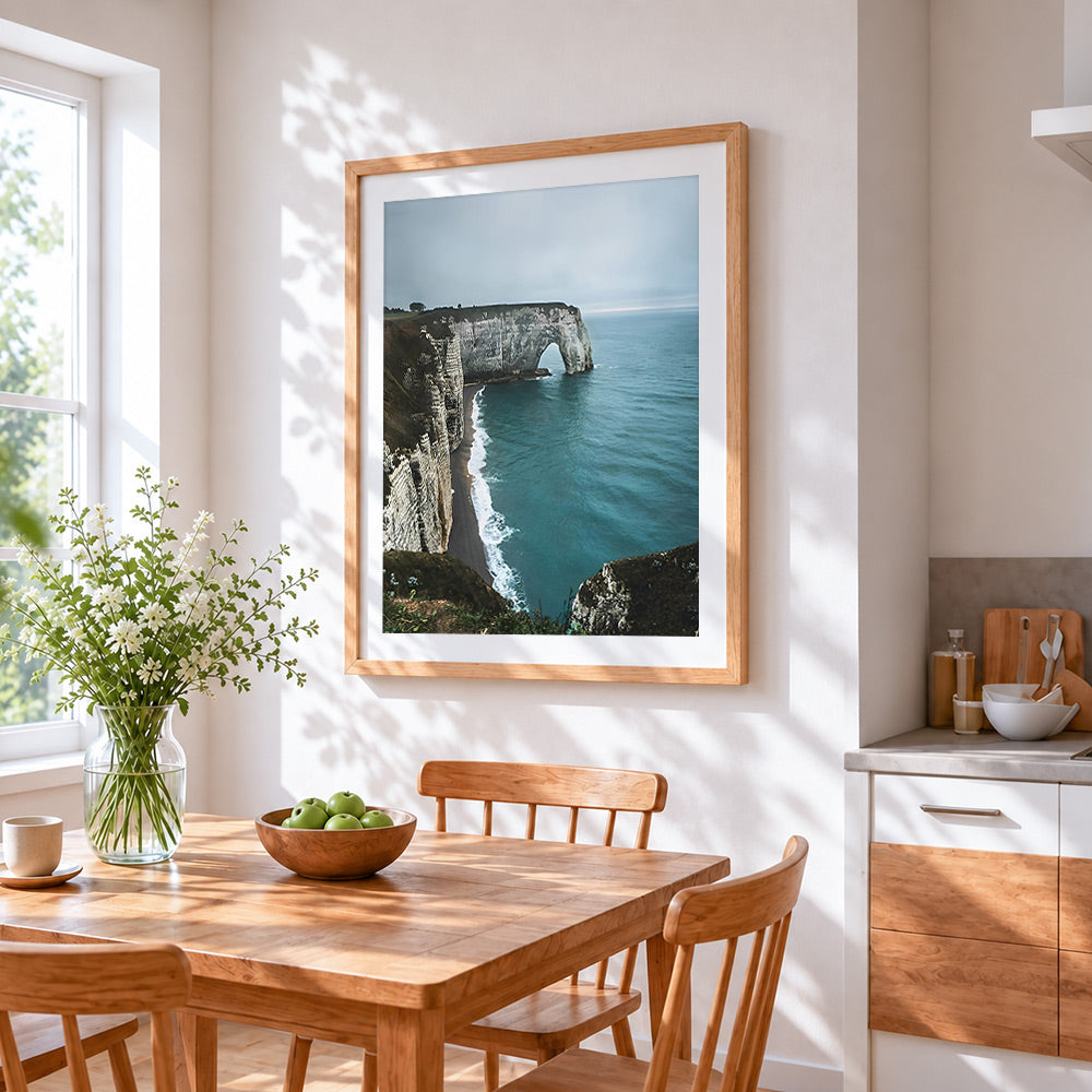 Dramatic coastal cliffs and sea arch cross stitch artwork displayed on wall as home decor