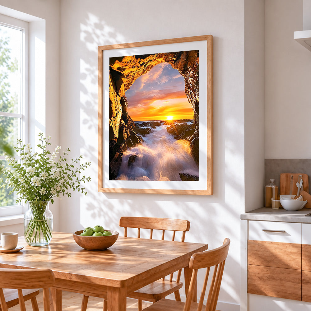 Dramatic sea cave sunset cross stitch artwork displayed on wall as home decor