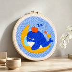 Dreamy whale and moon punch needle artwork displayed on a table