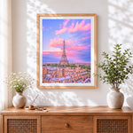 Finished eiffel tower and pink sunset cross stitch artwork displayed