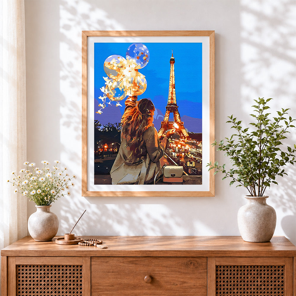 Finished eiffel tower night and woman cross stitch artwork displayed