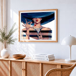 Elegant lady with martini and wide brim hat cross stitch artwork displayed on wall as home decor