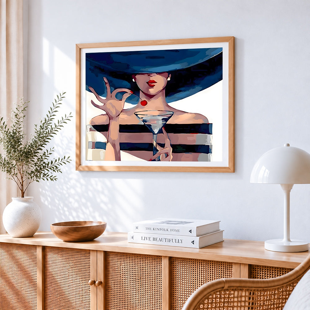 Elegant lady with martini and wide brim hat cross stitch artwork displayed on wall as home decor