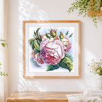 Finished elegant pink roses and buds cross stitch artwork displayed