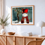 Elegant snowman with red hat cross stitch artwork displayed on wall as home decor