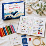 Embroidery stitch book gift set displayed with colorful floss, hoop and stitching tools