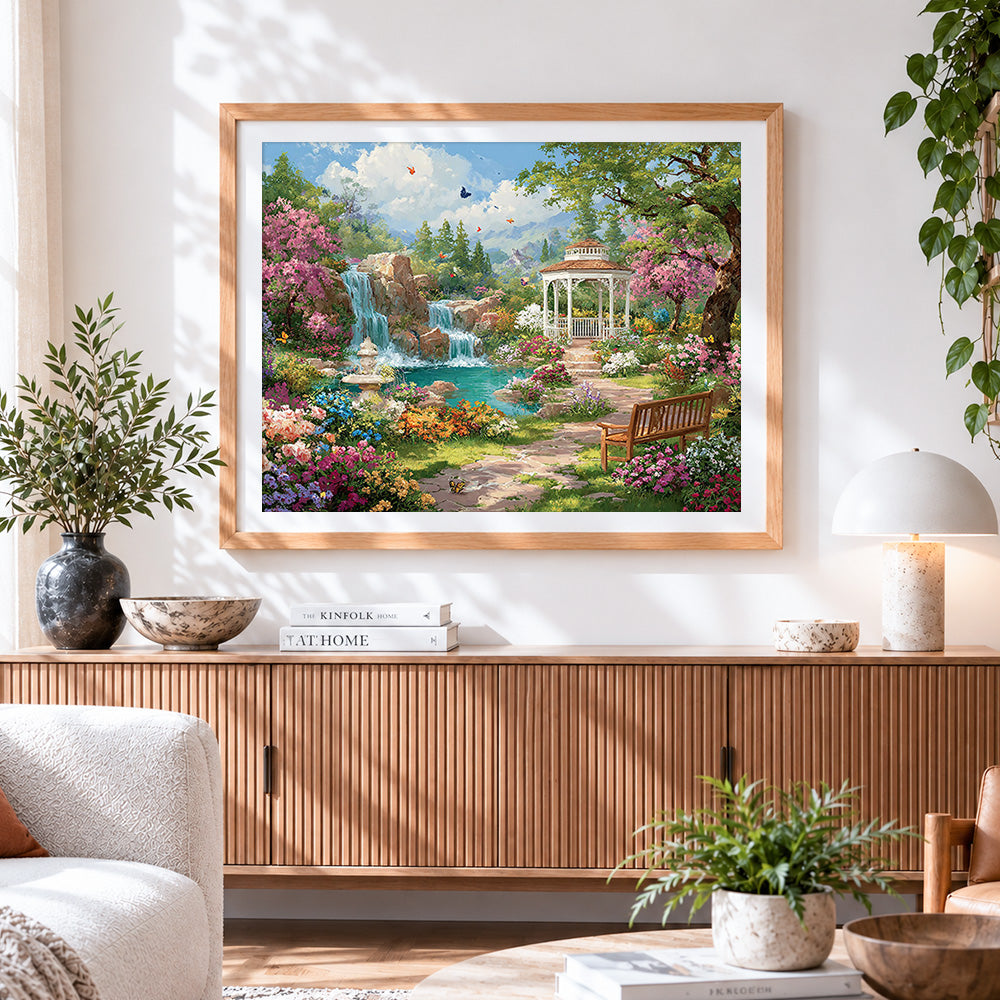 Finished enchanted garden waterfall and gazebo cross stitch artwork displayed