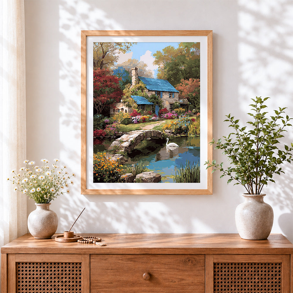 Finished english country cottage and swan cross stitch artwork displayed