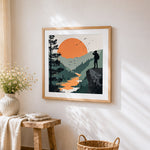 Explorer with binoculars on a cliff cross stitch artwork displayed on wall as home decor