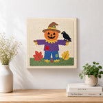 Finished fall pumpkin scarecrow artwork displayed on a wall
