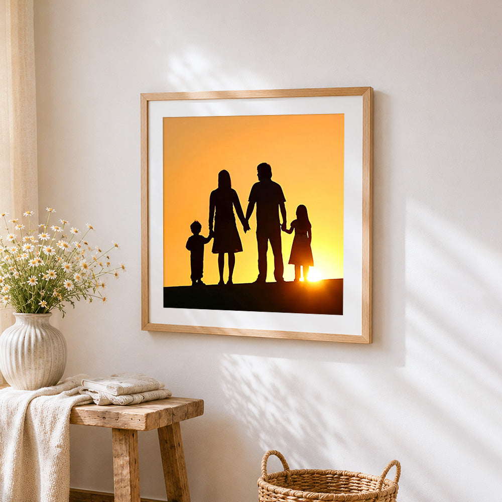 Family holding hands at sunset silhouette cross stitch artwork displayed on wall as home decor
