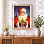 Finished father christmas holding a glowing tree cross stitch artwork displayed