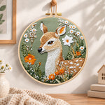 Fawn with daisies and orange blooms embroidery hoop wall art displayed as warm and cosy handmade home decor
