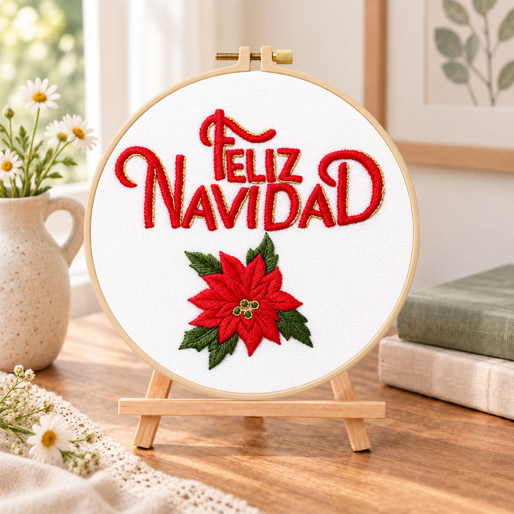 Feliz navidad poinsettia embroidery kit finished hoop displayed on a wooden stand as cozy tabletop decor