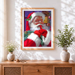 Finished festive father christmas going "shh!" cross stitch artwork displayed