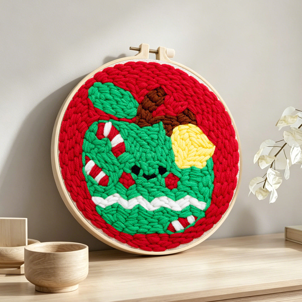 Festive green apple punch needle artwork displayed on a table