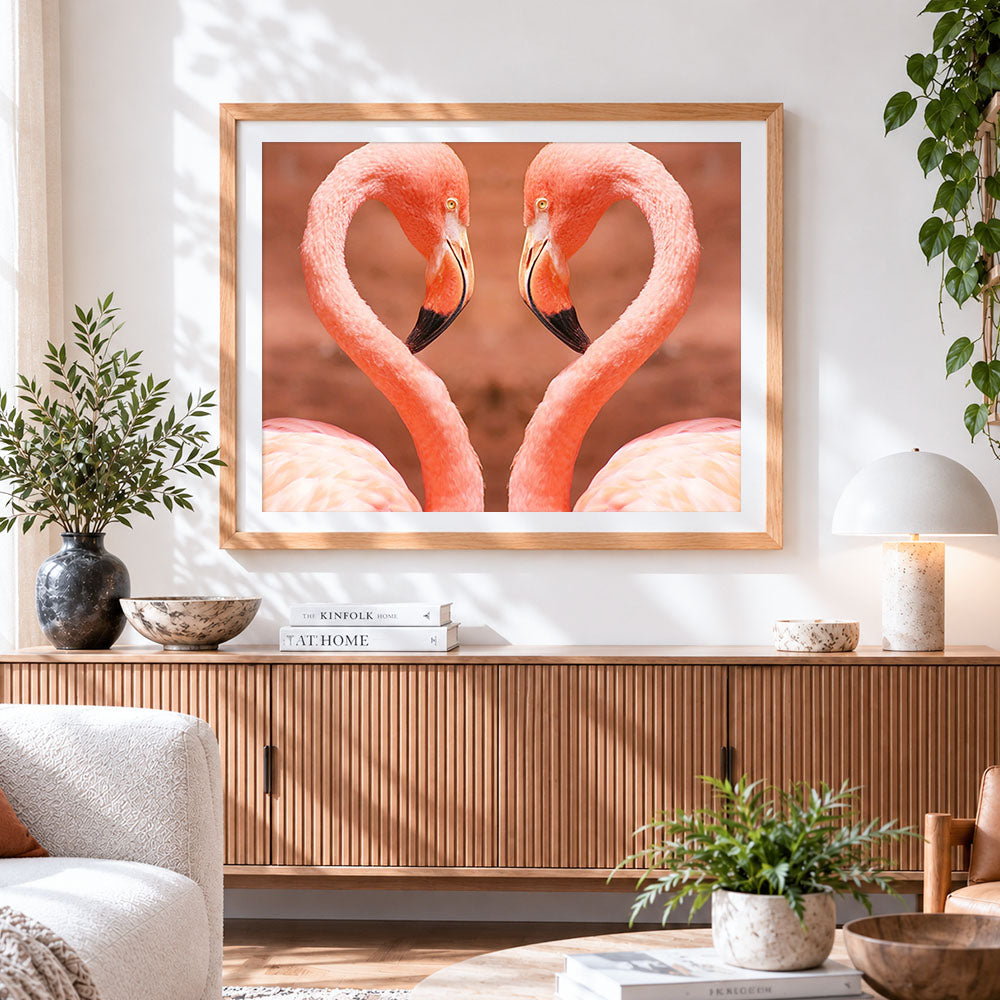 Finished flamingos forming a heart cross stitch artwork displayed