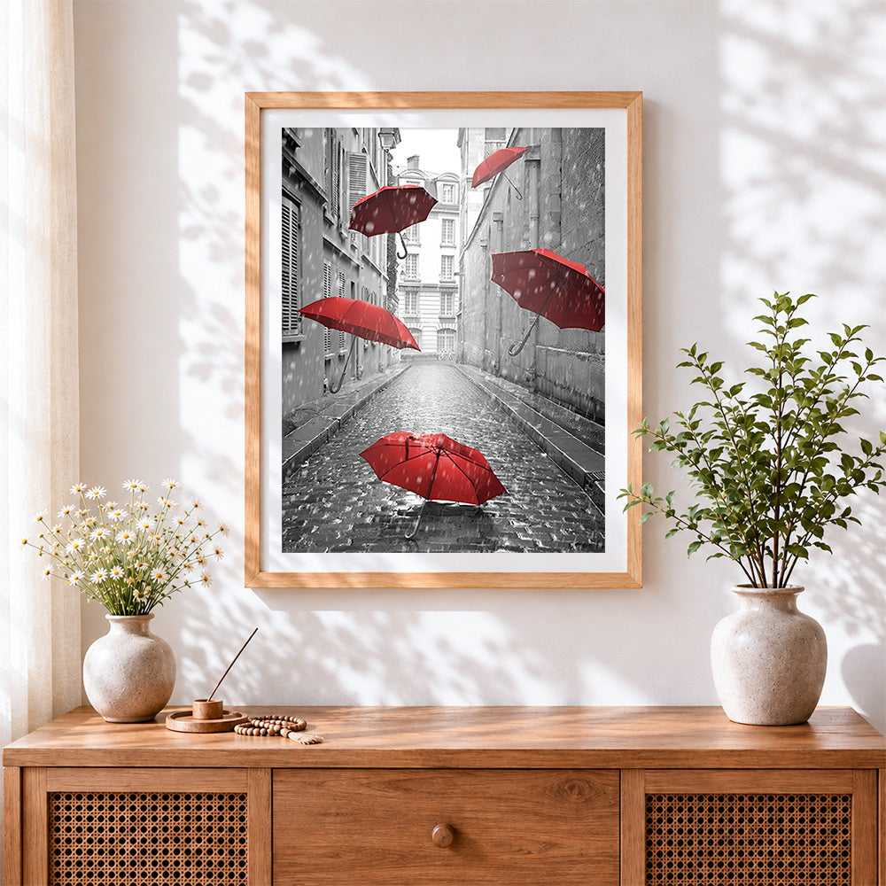 Finished floating red umbrellas cross stitch artwork displayed