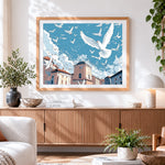 Finished flock of white doves flying over a city cross stitch artwork displayed