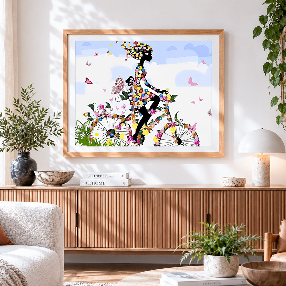 Finished floral bicycle woman silhouette cross stitch artwork displayed