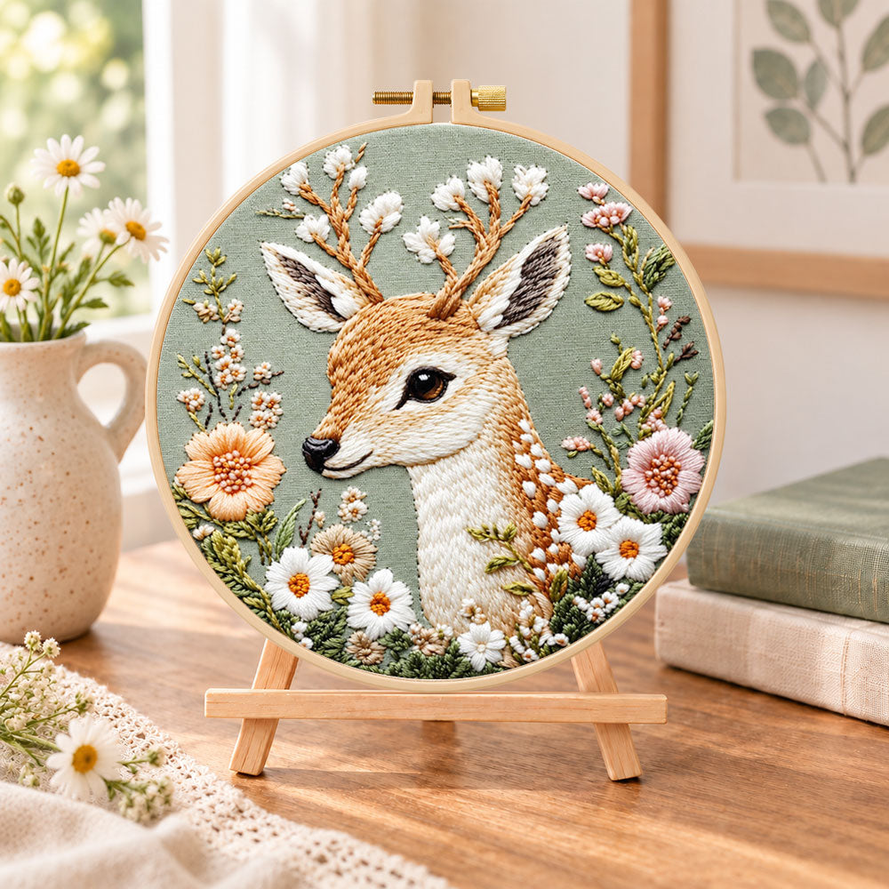 Floral fallow deer embroidery kit finished hoop displayed on a wooden stand as cosy tabletop decor