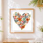 Finished floral heart illustration cross stitch artwork displayed