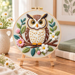 Floral owl on branch embroidery kit finished hoop displayed on a wooden stand as cosy tabletop decor