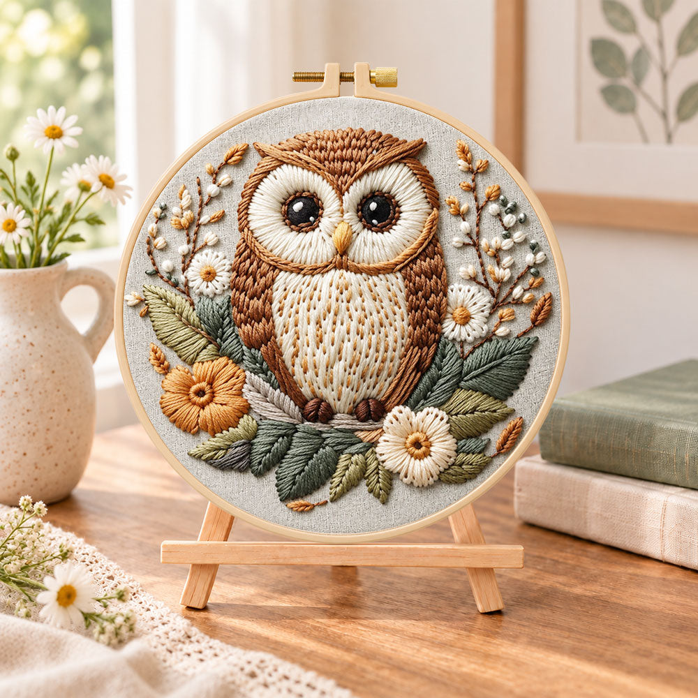 Floral owl portrait embroidery kit finished hoop displayed on a wooden stand as cosy tabletop decor
