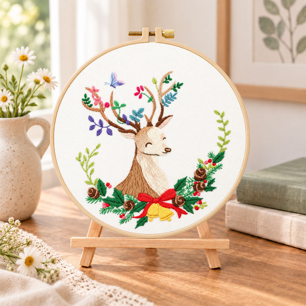 Floral reindeer art embroidery kit finished hoop displayed on a wooden stand as cosy tabletop decor
