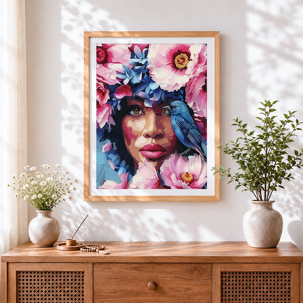 Finished floral woman with bluebird cross stitch artwork displayed
