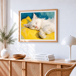 Fluffy white cat sleeping on a yellow pillow cross stitch artwork displayed on wall as home decor
