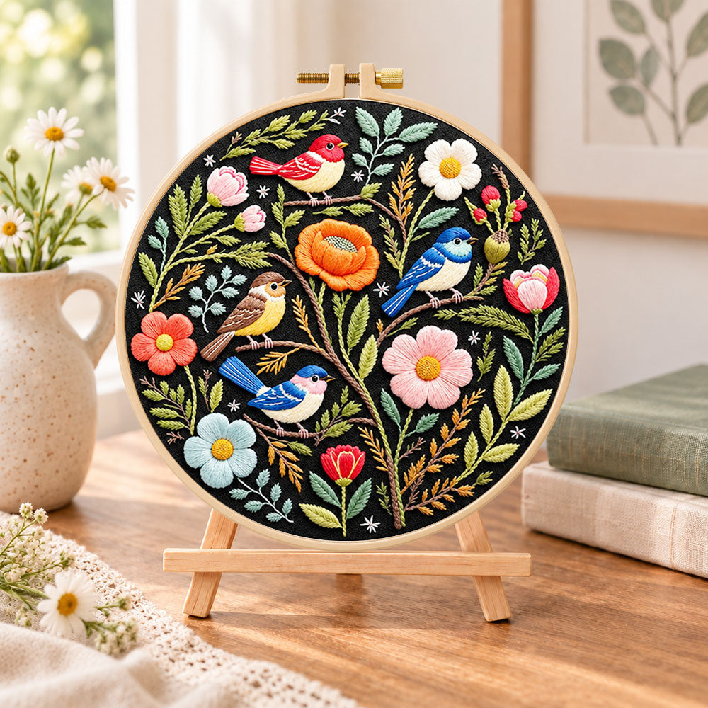 Forest birds and spring blooms embroidery kit finished hoop displayed on a wooden stand as cosy tabletop decor