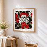 Fun skulls and red roses cross stitch artwork displayed on wall as home decor