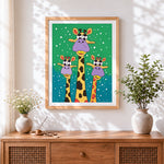 Finished funny cartoon giraffes in the snow cross stitch artwork displayed