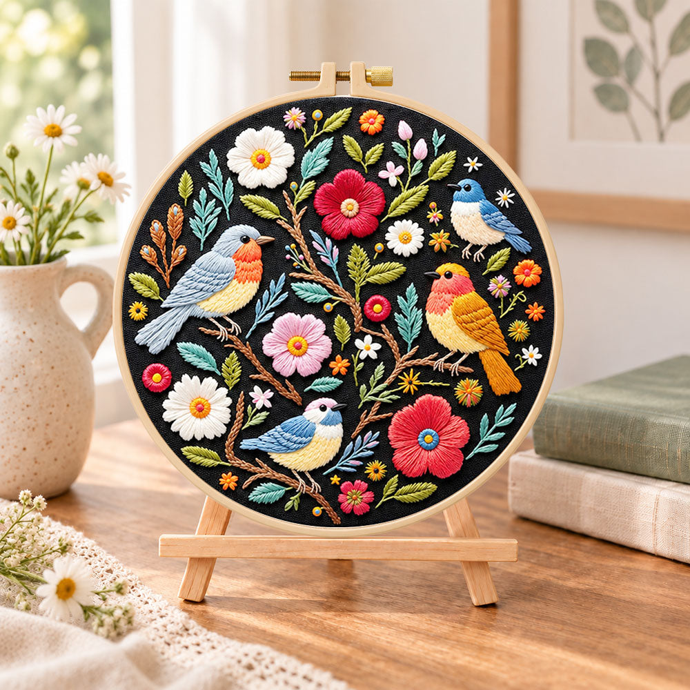 Garden birds and blossoms embroidery kit finished hoop displayed on a wooden stand as cosy tabletop decor