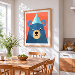 Geometric blue bear with party hat cross stitch artwork displayed on wall as home decor