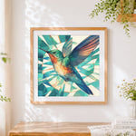 Finished geometric hummingbird in flight cross stitch artwork displayed
