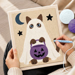 Creating handmade ghost cat holding pumpkin treat bucket punch needle artwork