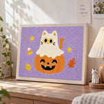 Ghost cat on pumpkin punch needle artwork displayed on a table
