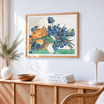 Ginger cat and blue irises cross stitch artwork displayed on wall as home decor