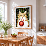 Ginger cat holding a red bauble cross stitch artwork displayed on wall as home decor