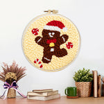 Finished gingerbread man with santa hat artwork displayed on a wall