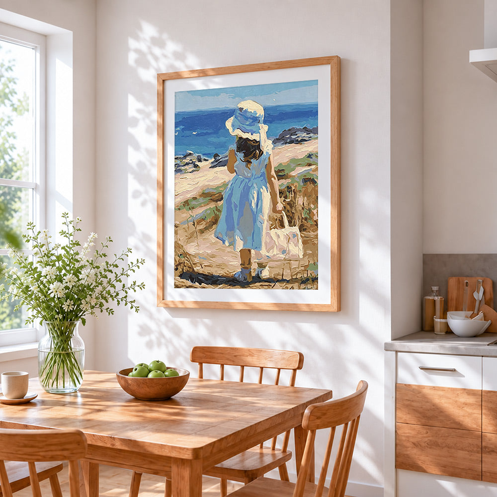Girl in blue dress by the sea cross stitch artwork displayed on wall as home decor