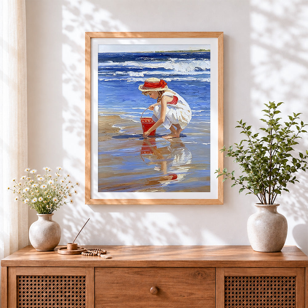 Finished girl on beach with red bucket cross stitch artwork displayed